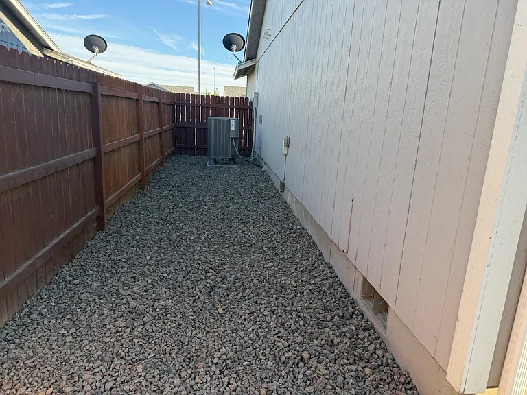 Side of home, newly landscaped with crushed rock.