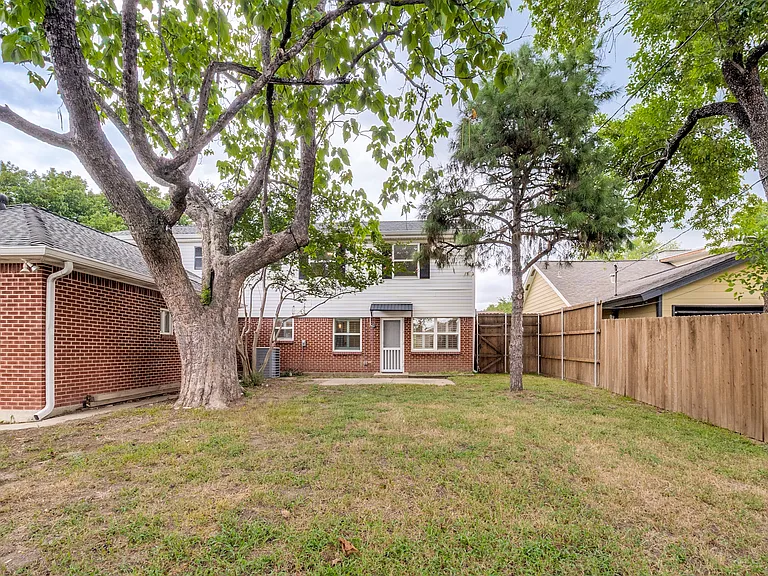 Private fenced backyard with mature trees.