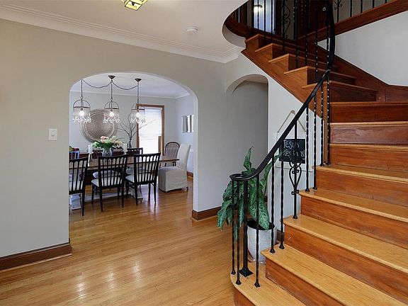 A graceful stairway and warm wood floors - in entry foyer.