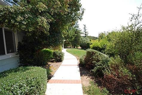Walkway from driveway to the front entrance. The property is privately secluded between the front an