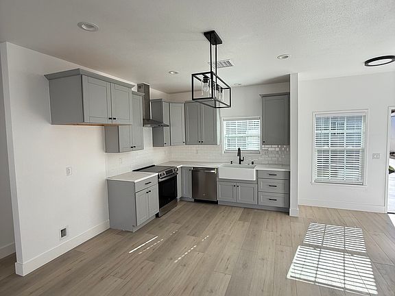 Kitchen area with a farm sink, dishwasher, stove, and refrigerator coming soon. Everything is NEW.