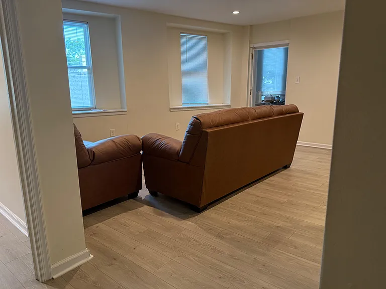 Living area with durable wood-look flooring, recessed lighting, and multiple windows for comfortable everyday lounging.