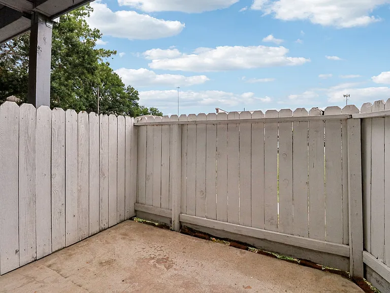 Charming outdoor patio with a wooden fence, perfect for private relaxation under the open sky. Charming outdoor patio with a wooden fence, perfect for private relaxation under the open sky.