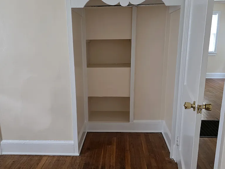 bedroom 1 closet with shelves and bar
