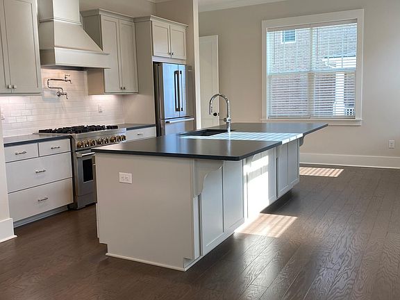 Soapstone countertops & custom cabinets with storage under the island and a large walk-in pantry.