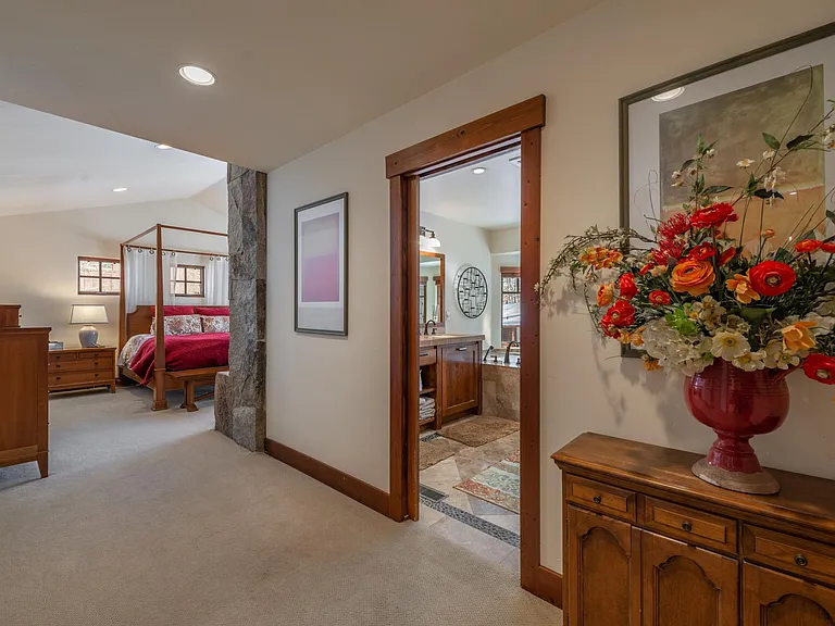 The primary bedroom down stairs features a king size canopy bed and remote start stone and iron fireplace.