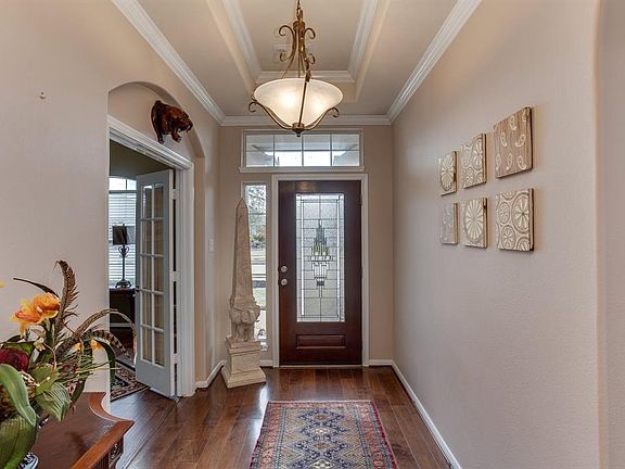 Welcoming porch with gorgeous beveled glass wood door, transom and sidelight. Home comes equipped with gutters.