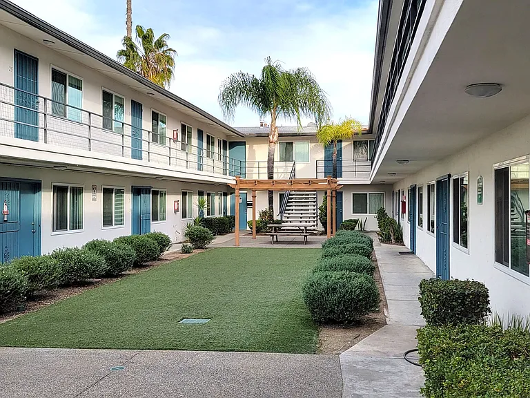 Courtyard with palm trees and nice landscaping at Orlando Woods Apartments in El Cajon, California.