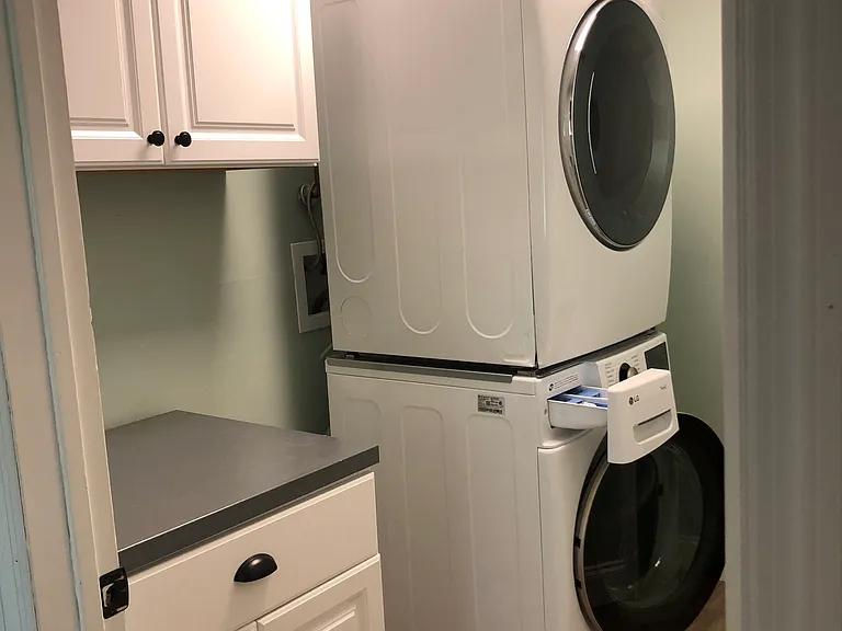 separate laundry room with white cabinet and LG front loaders