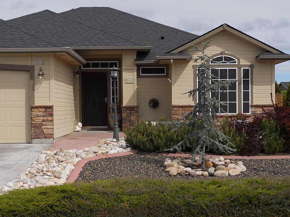 Front of home features xeroscape with stamped concrete patio