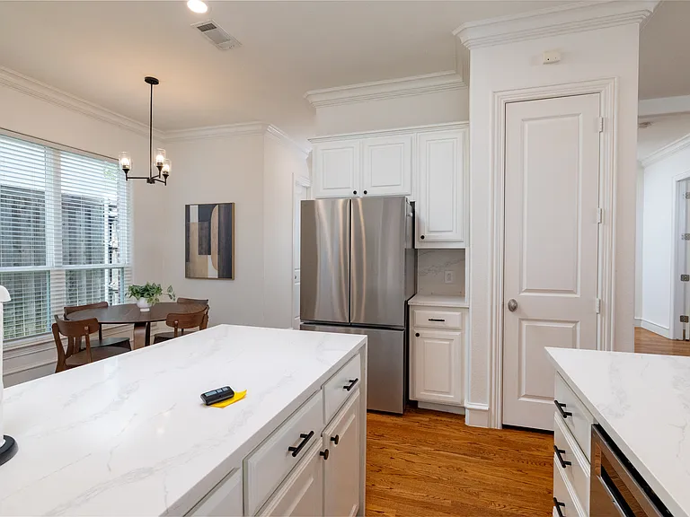 Seamless flow from the gourmet kitchen to the sunlit dining area.