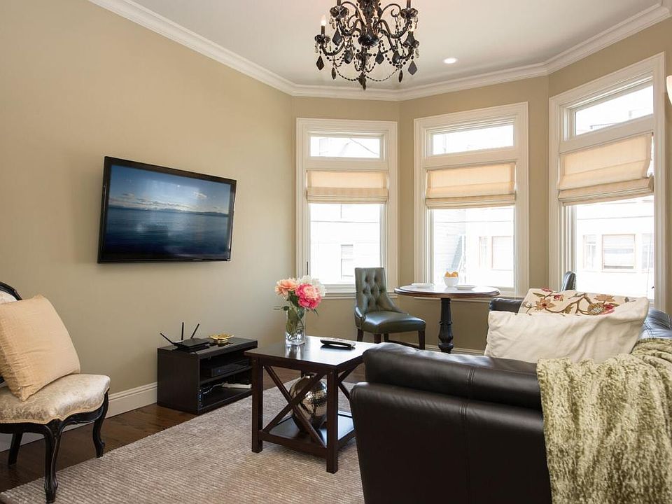 Living room with large bay windows. Custom roman shades