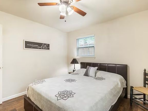 Guest bedroom with queen beds. Sitting chair and end table with lamp for comfort. Linens provided with extra closet space