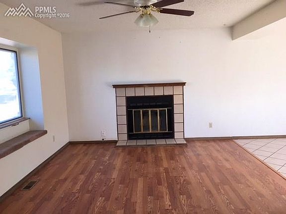 Living room with boxed front window, fireplace, wood laminate floor