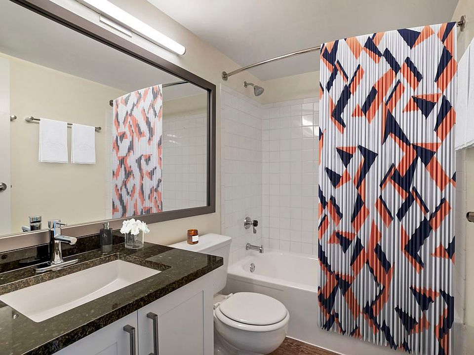 Renovated Package II bath with new white cabinetry, granite countertops, and hard surface flooring