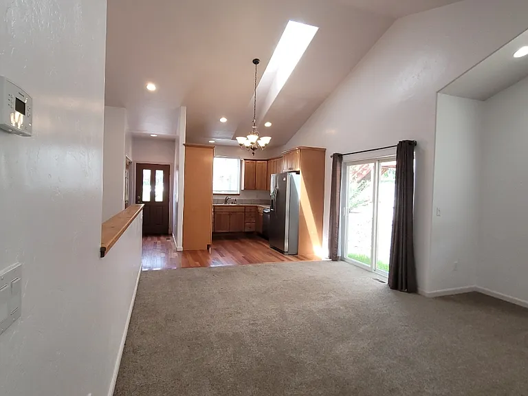 Looking from primary bedroom hall to entry and kitchen