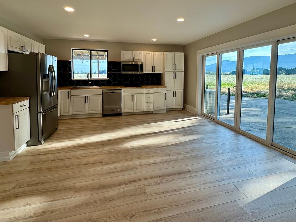 Open floor plan kitchen and living area with sliding glass door views of the Coburg Hills.