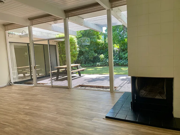 Photo taken from the living room towards the back yard, including fire place, includes new hardwood flooring