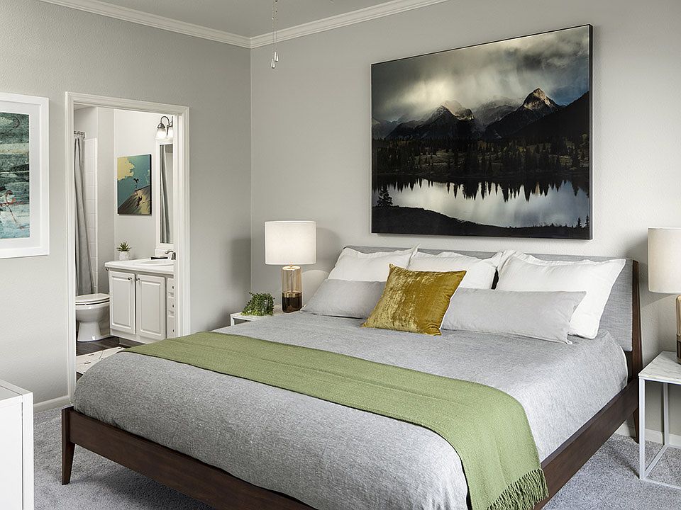 Spacious apartment bedroom with carpeted floors overlooking bathroom.