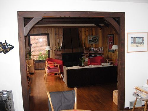 Living room and fireplace from dining area. Note the unique woodwork.