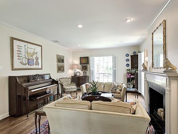 Gracious formal living room. Original mock fireplace with tile, crown moulding. Beautiful antique sc