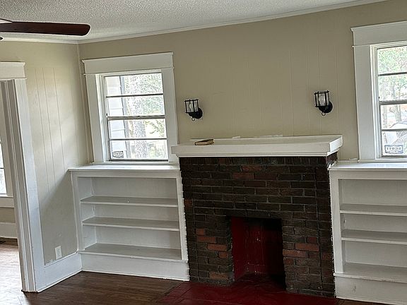 freshly painted walls in den with built in bookshelves and hardwood floors.