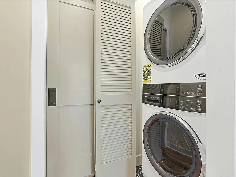 In-unit laundry features new washer and dryer inside closet in hallway.