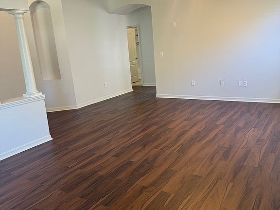 Entry with column, tray ceiling, and arches throughout home