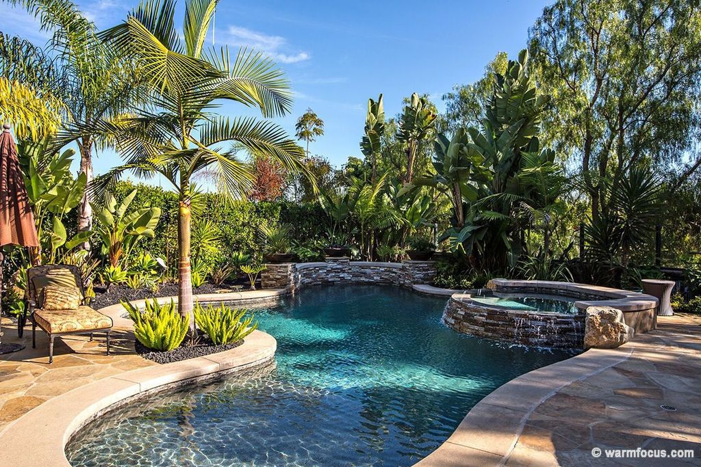 Tropical Swimming Pool with exterior stone floors & Fence in Carlsbad ...