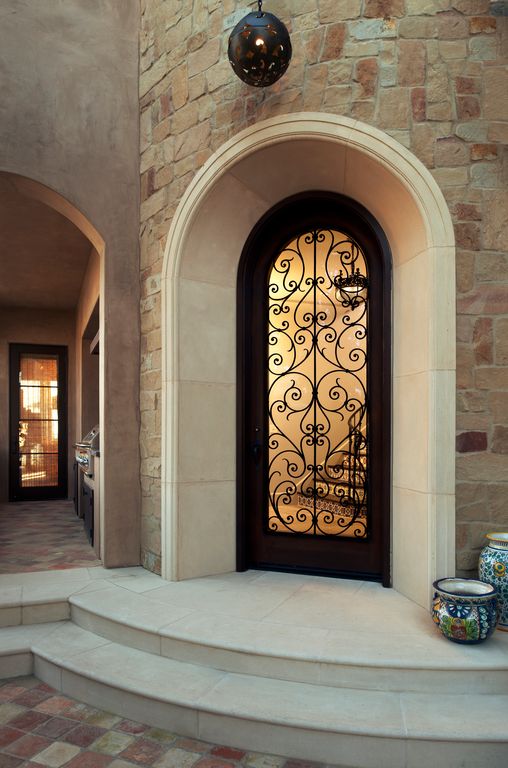Mediterranean Front Door with exterior stone floors by Tommy Chambers