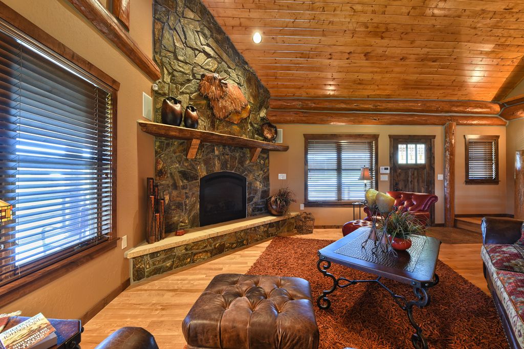 Rustic Living Room with Hardwood floors & stone fireplace ...