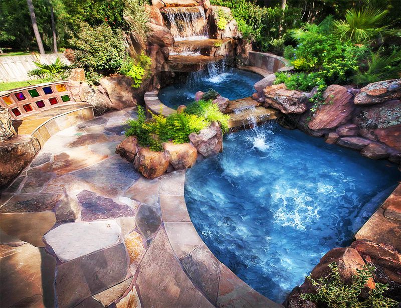 Rustic Swimming Pool with Water feature & exterior stone floors