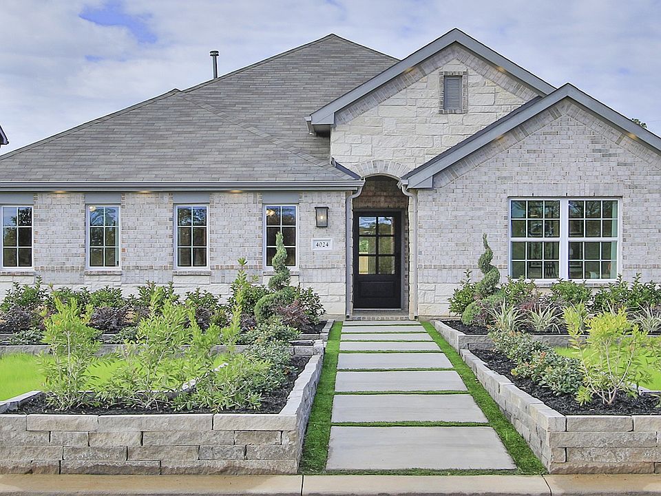 Luxurious stone facade with pristine landscaping in Colony at Pinehurst, Texas.
