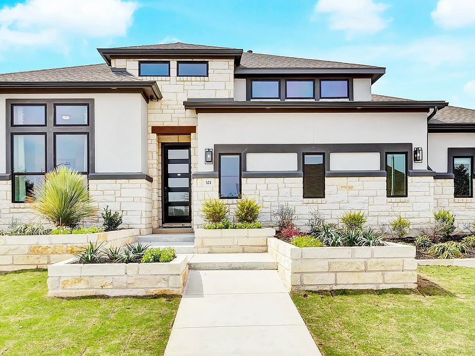 Elegant stone and stucco facade with expansive windows in Hawkes Landing. Luxurious curb appeal.