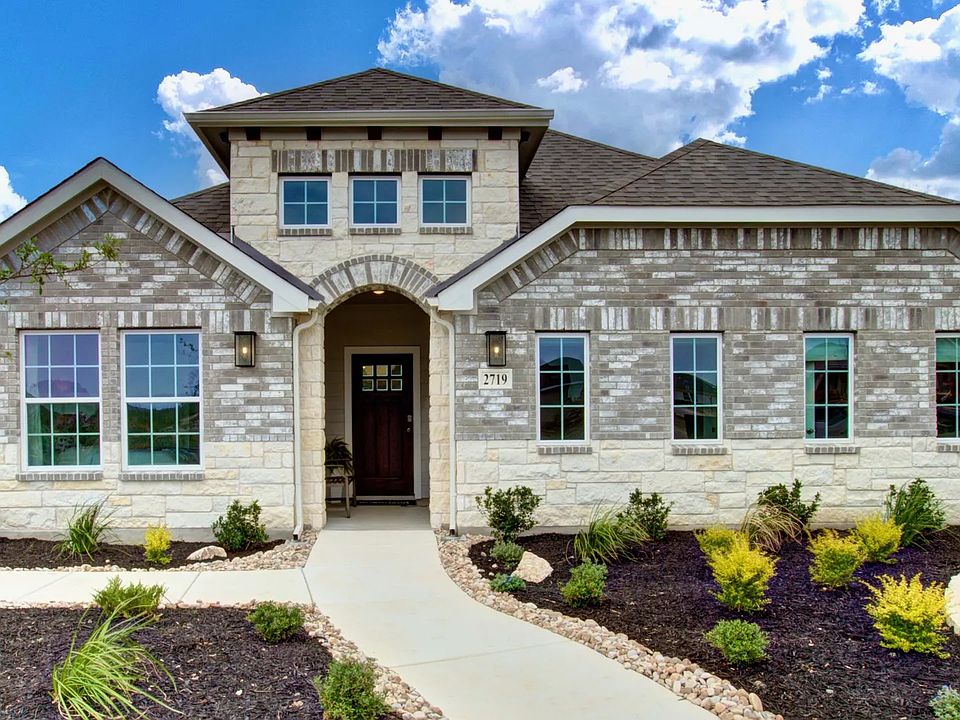 Elegant brick facade with arched entrance and pristine landscaping in Prairie Green community.