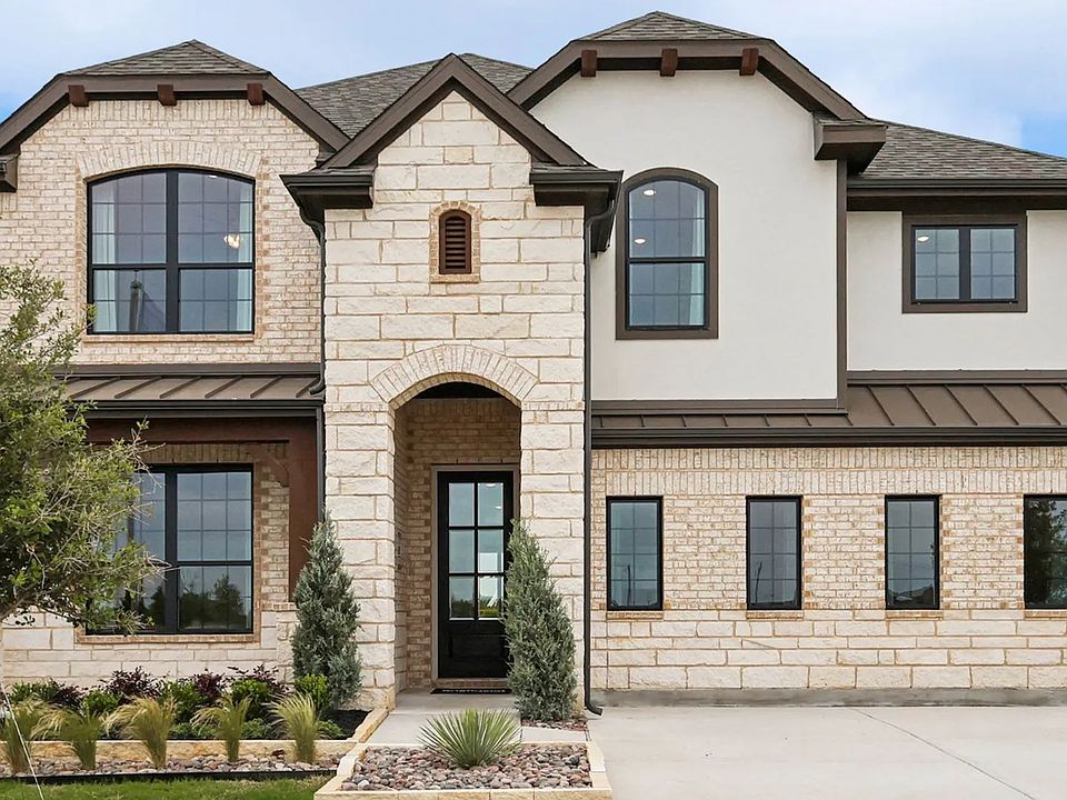 Elegant stone facade with arched entryway and expansive windows exemplifies luxury in Hulen Trails.