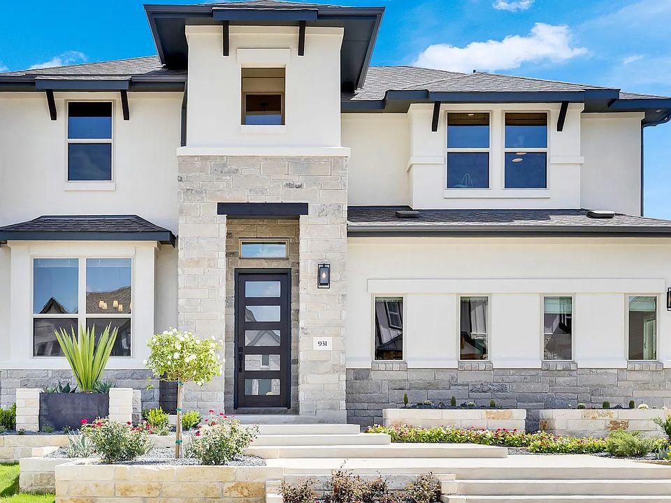 Exquisite stone facade and expansive windows define this stunning Sunfield community residence.