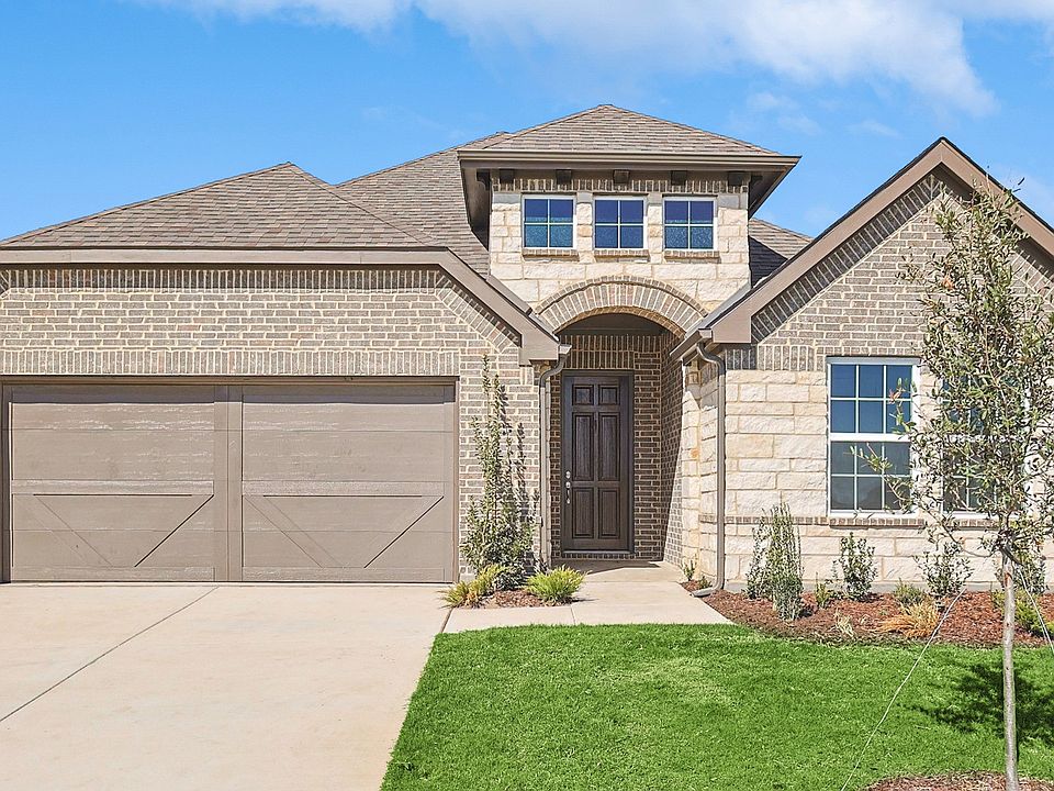 Brick facade, elegant archway, and lush landscaping define this Westland Ranch home.