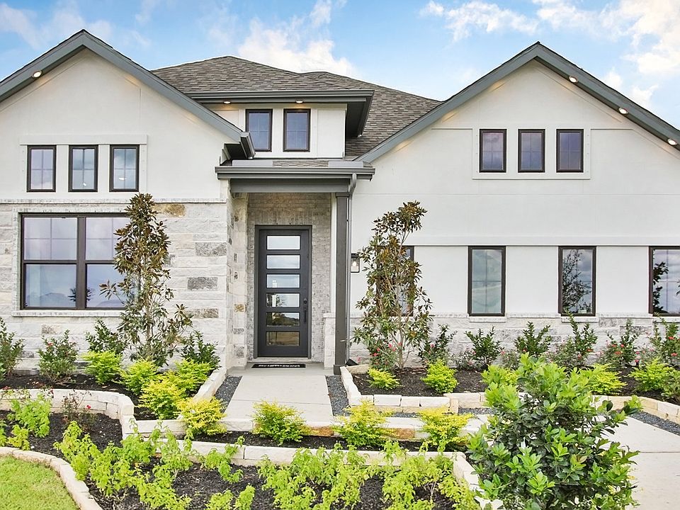 Elegant white facade with stone accents and pristine landscaping in Coastal Point community.