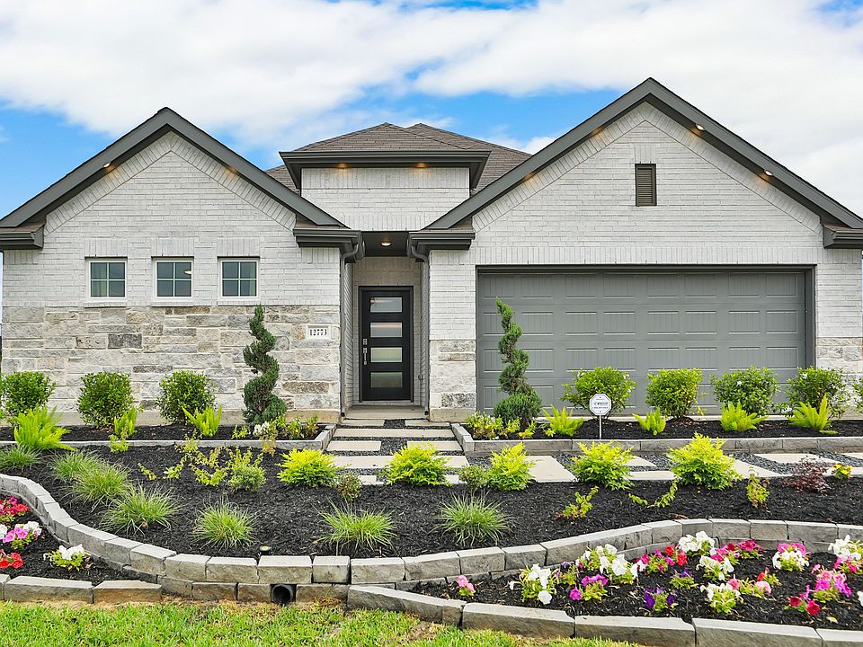Whisper South home showcases exquisite brickwork and stone accents, complemented by lush, curated ga