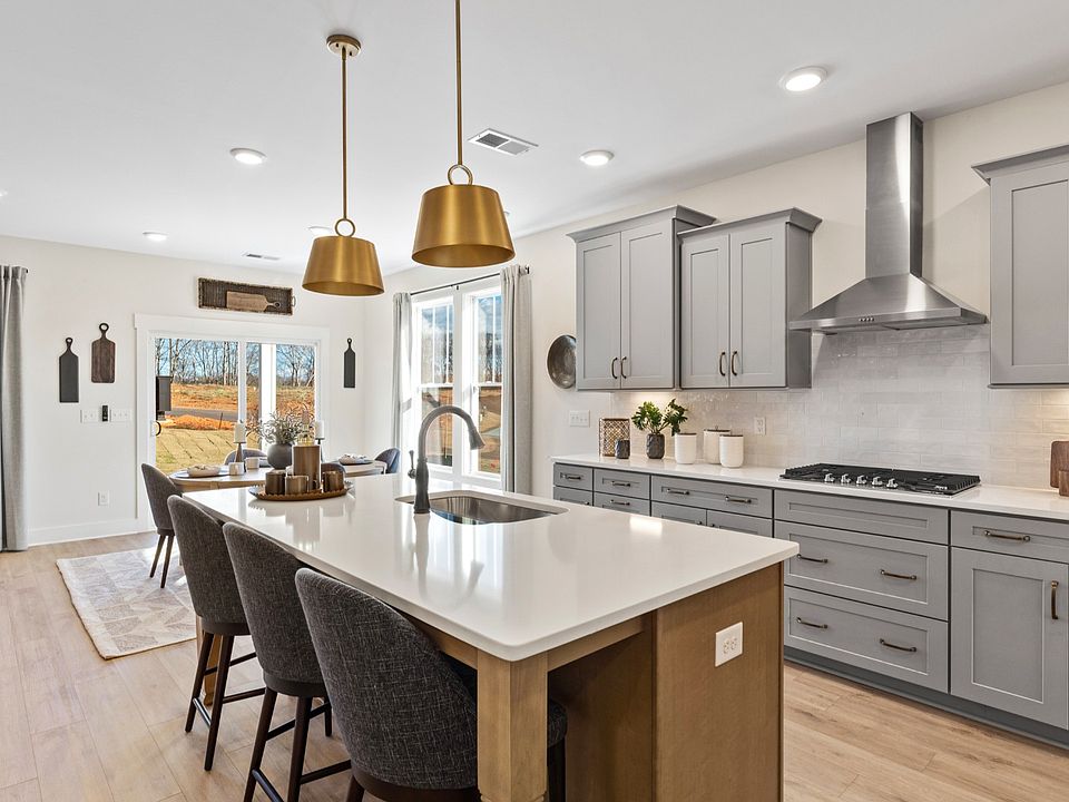 Luxe kitchen with gold accents and large wooden island at Iris Meadows by DRB Homes in Moore, SC