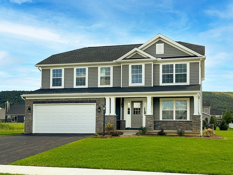Front view of a two-story home with gray siding, stone accents, white trim, and a double garage