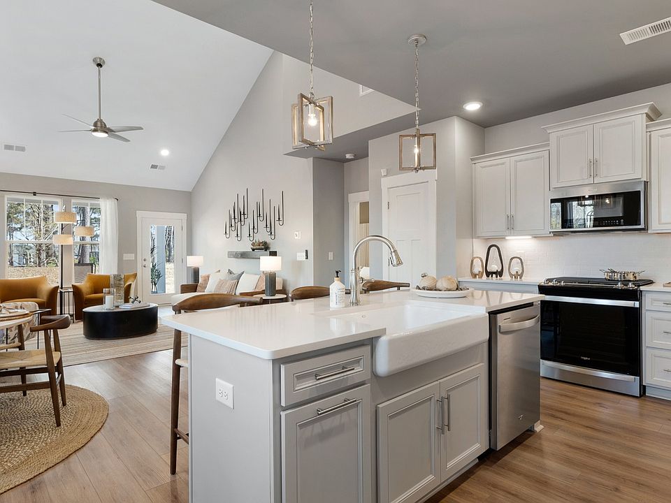 Open concept design with kitchen island overlooking the family room with two story ceilings at Villa