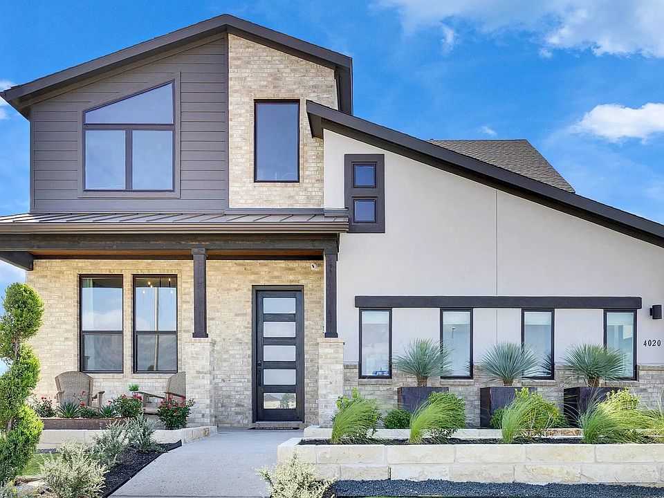 Elegant stone facade complements sleek windows in a pristine landscaped setting at Lakeside Meadows.