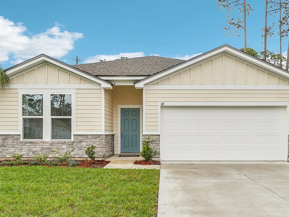 Elegant Palm Coast residence with stone accents and lush landscape embodies timeless sophistication.