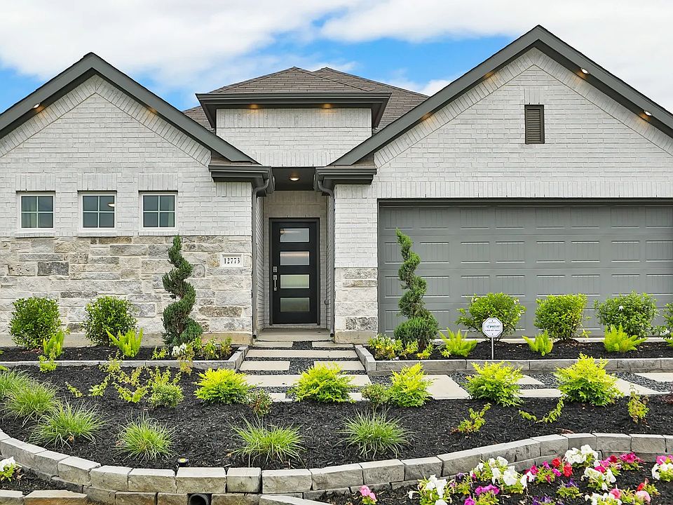 Whisper South home showcases exquisite brickwork and stone accents, complemented by lush, curated ga
