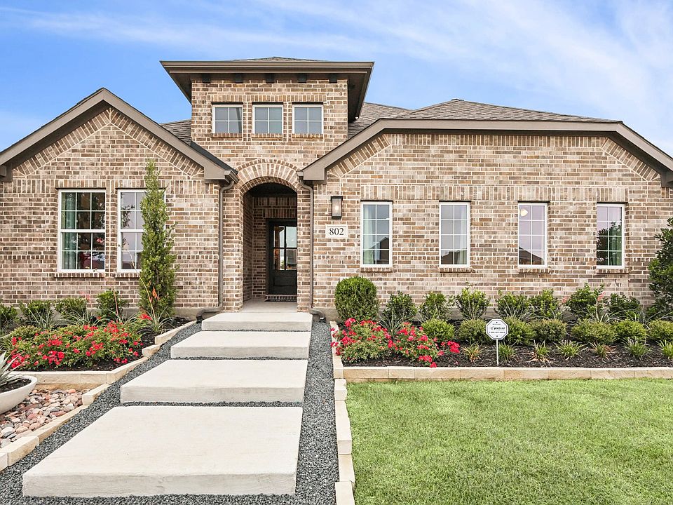 Stunning brick facade with elegant arched entryway and lush gardens at Simpson Crossing.