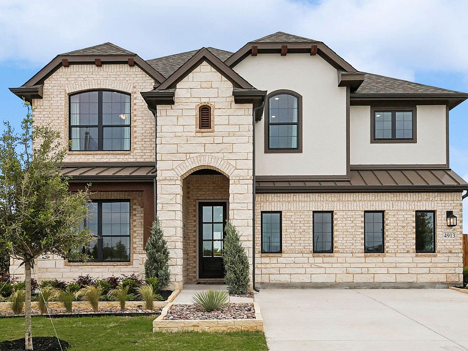 Elegant stone facade with arched entryway and expansive windows exemplifies luxury in Hulen Trails.