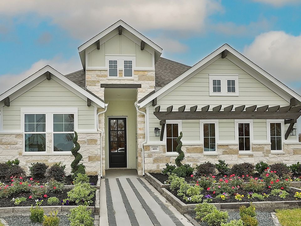 Experience elegance with stone accents and lush gardens at this Brewster Pointe Craftsman home.