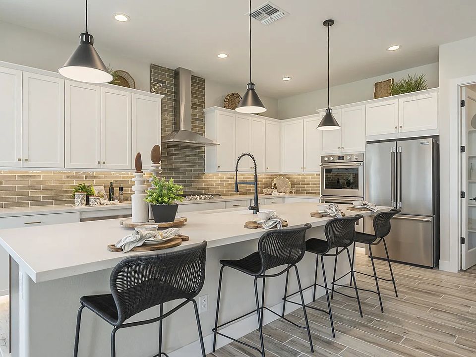 This Hacienda at Estrella kitchen features luxe white cabinetry, sophisticated island, and premium s